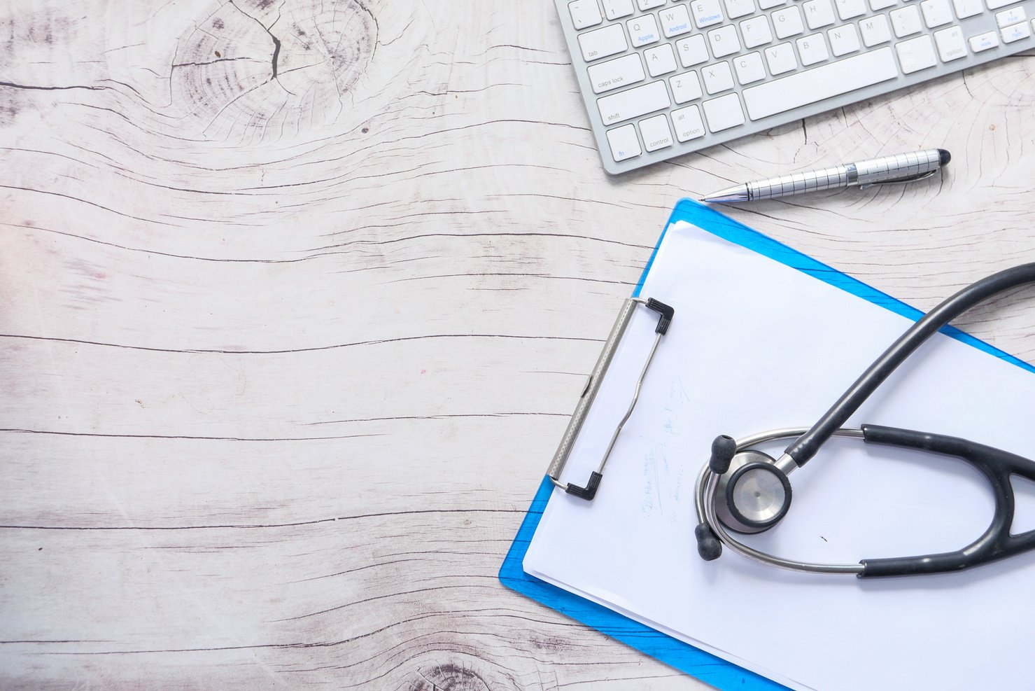 Doctors Workplace with Container, Keyboard and Prescription on Desk.